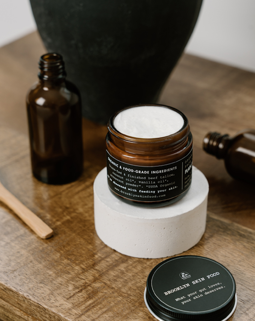 Skincare product jar with droppers on a wooden surface