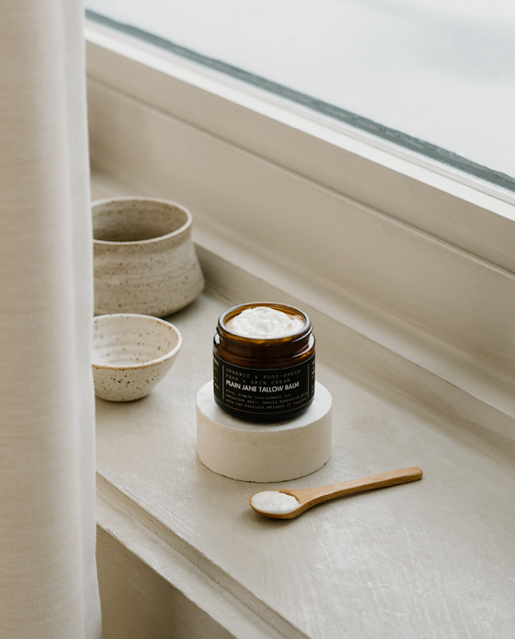 Jar of cream on a windowsill with bowls and a spoon